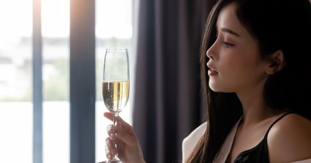 ソファでシャンパンを見る女性