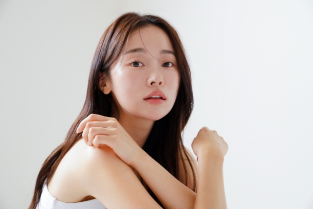 ノースリーブを着た体の前で腕をクロスした黒髪の女性
