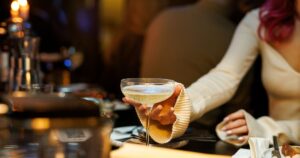 シャンパンをカウンターから渡す女性