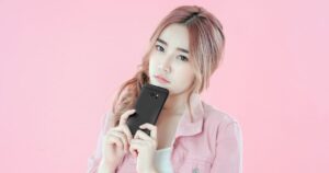 携帯を持って悩む女性