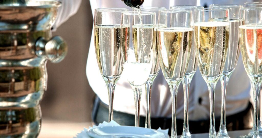 お酒が注がれた複数のシャンパングラスとボーイ