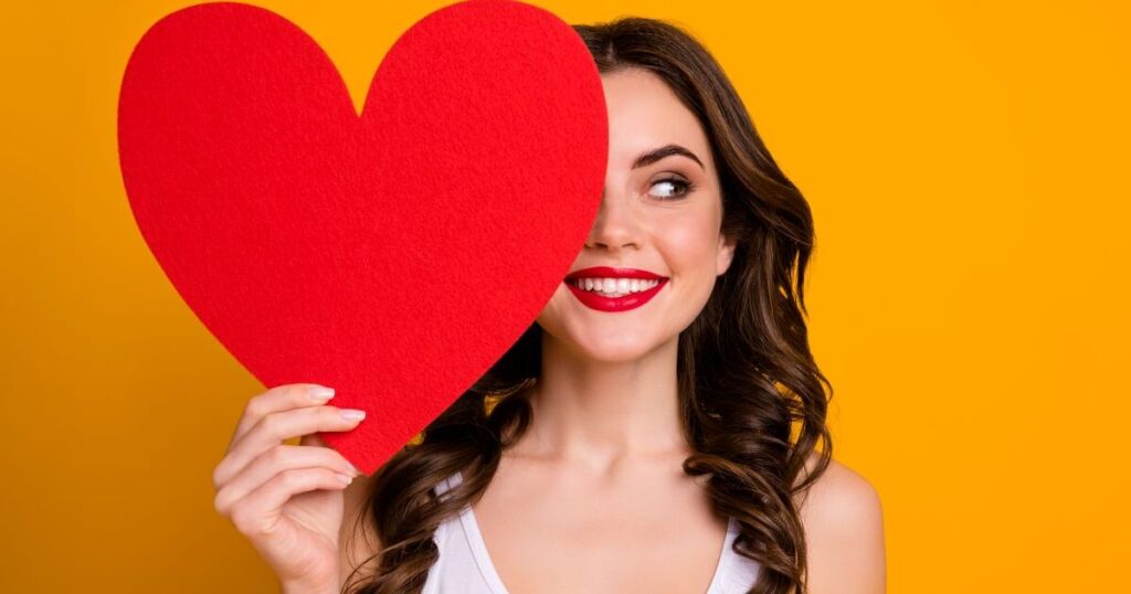 片目をハートマークで隠す女性