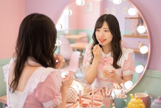 メイクをするメイド服の女性