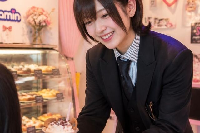 男性の服装をした若い日本人のメイド嬢
