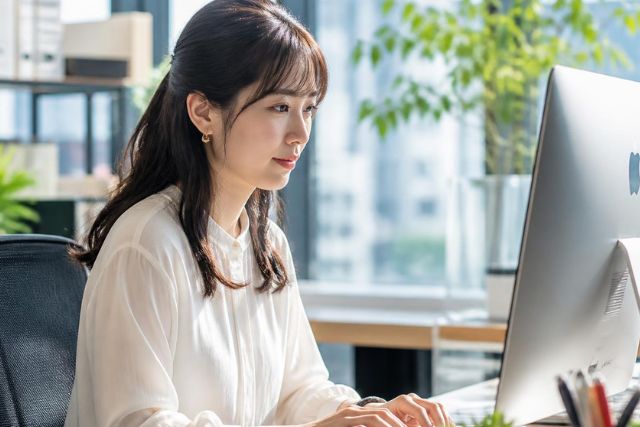 オフィスでPCをタイプする若い女性