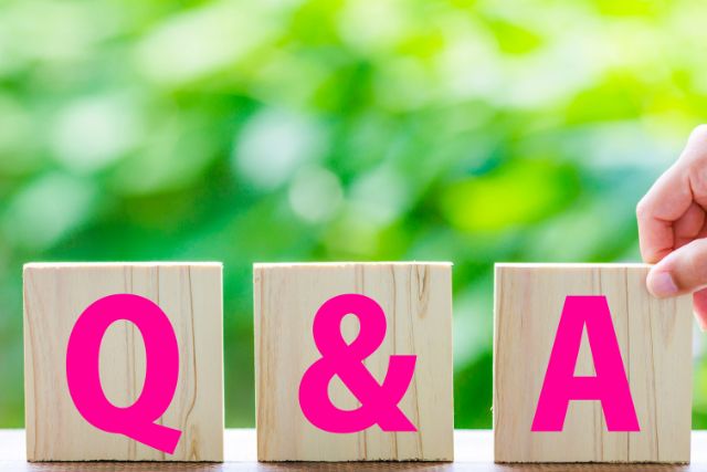 Q＆Qと書かれた木のブロックを触る手元
