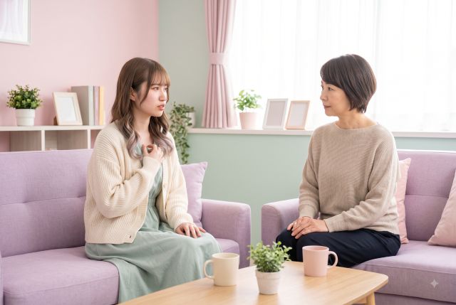 ソファに座って親と話す女性