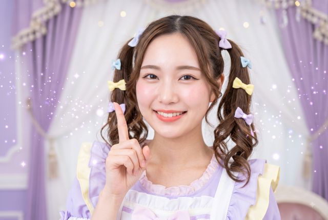 人差し指を立てるツインテールの女性