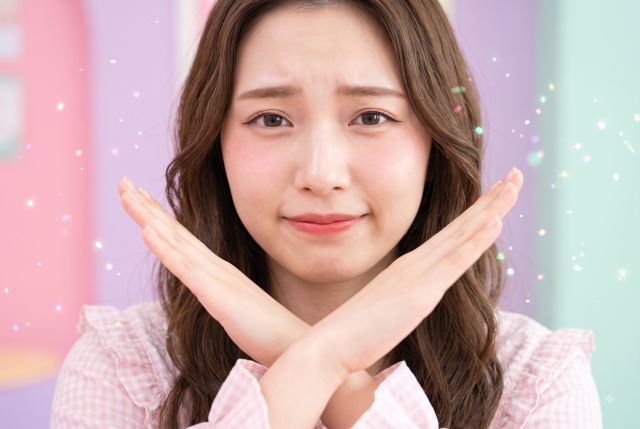 バツサインをする女性