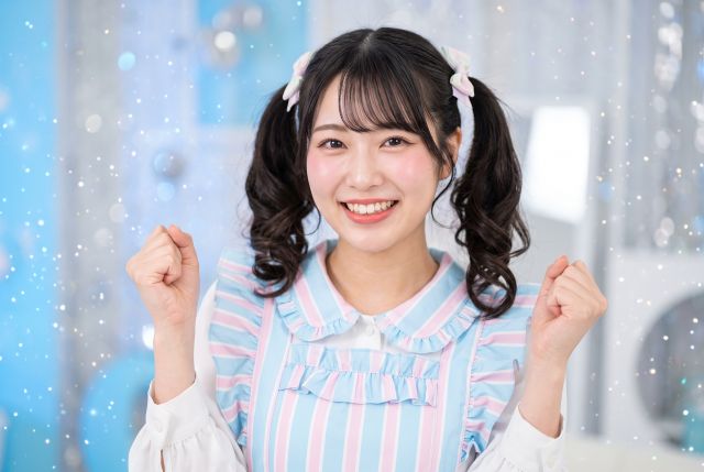 ガッツポーズするメイド服の女性